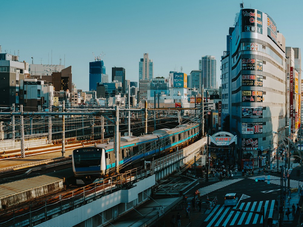 A city train running alongside buildings.